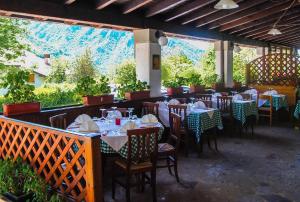 Zone康佳维尔德酒店的餐厅配有桌椅,位于山脉的背景中