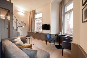 汉堡OBERDECK Studio Apartments - Adults only的客厅配有沙发、桌子和窗户