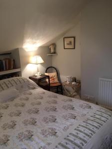 阿伯加文尼The Old Rectory Bed & Breakfast的一间卧室配有一张带灯和椅子的床
