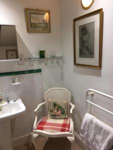 阿伯加文尼The Old Rectory Bed & Breakfast的一间带水槽和毛巾椅子的浴室