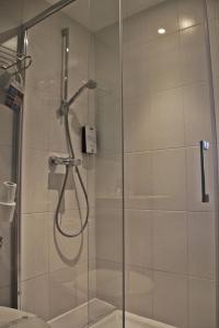 沙勒维尔-梅济耶尔基里亚德查尔勒维勒梅兹尔酒店的浴室里设有玻璃门淋浴