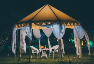 布什格尔Rawai Luxury Tents Pushkar的帐篷下配有椅子和桌子