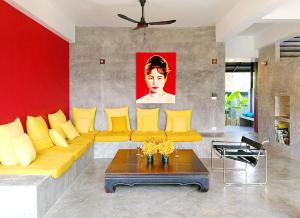 湄林平泳池2号别墅的客厅配有黄色的沙发和桌子