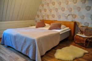 Kokemäki玛雅提拉马特卡路阿里克拖拉酒店的一间卧室配有一张床、一把椅子和地毯