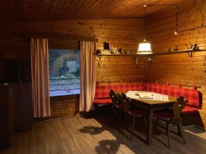 萨洛尔诺Chalet San Valentino的一间带桌椅和窗户的用餐室
