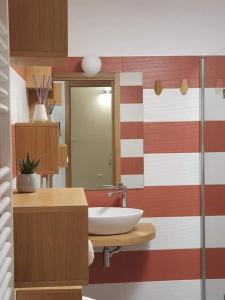 蒙特堡Hotel Miramonti的浴室设有白色水槽和红色及白色条纹