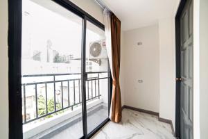 曼谷RoomQuest Sukhumvit36 BTS Thonglor的客房设有大窗户和阳台。
