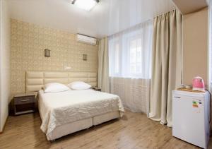 符拉迪沃斯托克卡门旅馆的卧室配有白色的床和冰箱。