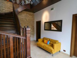 布拉索夫普拉托别墅酒店的客厅设有黄色沙发和楼梯。