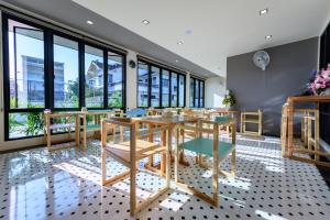 素叻Top Residence的一间带桌椅和窗户的用餐室