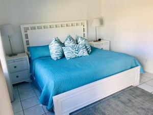 帕诺滩潮汐度假酒店的一间卧室配有一张带蓝色床单和枕头的床。