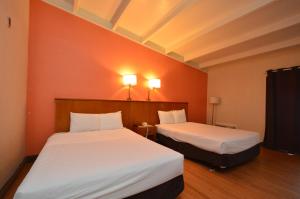 克利尔沃特Clearwater Hotel的橙色墙壁客房的两张床