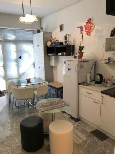 萨格勒布Leptir的厨房配有桌子、小桌子和冰箱。