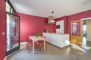 安特卫普Apartment with Rooftop Terrace in the Heart of Antwerp的厨房设有红色的墙壁和桌椅