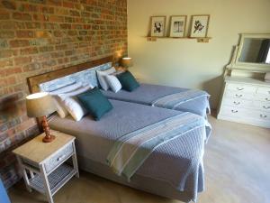 姆巴巴内Mkhiweni Villa at Dombeya Wildlife Estate的卧室设有2张床,设有砖墙