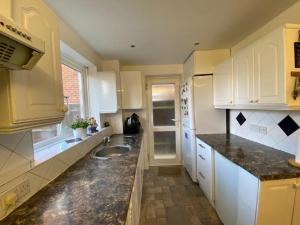 艾尔斯伯里Lovely Homes的厨房配有白色橱柜和水槽