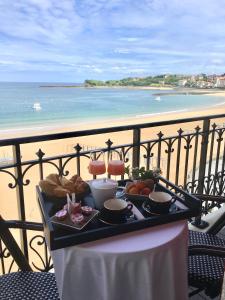 圣让-德吕兹Hôtel de la Plage - Saint Jean de Luz的一张桌子上的食品托盘,享有海滩美景
