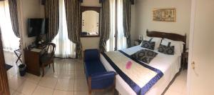 都灵萨沃意亚别墅酒店的一间卧室配有一张带蓝椅的床和电视。