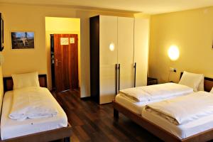 阿尔特多夫金钥匙酒店及餐厅的一间设有两张床的房间和一个橱柜