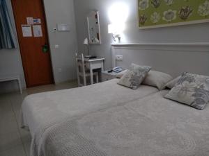 塞维利亚戈雅酒店的一间卧室配有一张大床和两个枕头