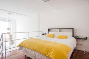 布宜诺斯艾利斯Luminosos Loft En Recoleta 2 Cuadras Del Subte的一间卧室配有一张带黄色床单的大床