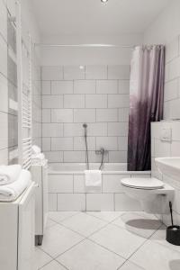 美因河畔法兰克福法布里克套房酒店 的白色的浴室设有浴缸、卫生间和水槽。