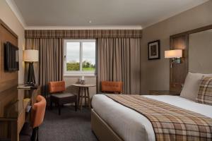 拉克霍尔索兰德斯公园酒店的酒店客房设有床、桌子和窗户。
