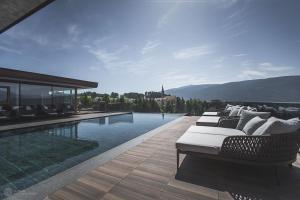 特伦托Terentnerhof 4*S active & lifestyle hotel的一座房子旁带躺椅的游泳池