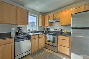 丹佛LoHi Apartment with Patio 1 Mi to Downtown Denver!的厨房配有木制橱柜和不锈钢用具