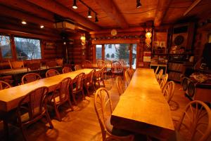 二世古伍迪诺特旅馆的用餐室配有木桌和椅子