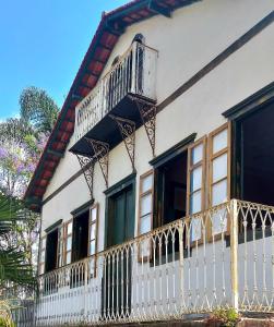 帕萨夸特鲁Hostel Pousada Harpia的房屋设有白色的围栏和阳台
