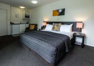 基督城棕榈机场汽车旅馆的一间带大床的卧室和一间厨房