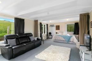 Company BayMacbay Retreat - Macandrew Bay Holiday Home的客厅配有沙发和1张床
