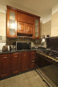 开罗Cozy modern apartment的厨房配有木制橱柜和炉灶烤箱。
