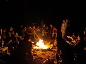 圣弗朗索瓦小河Auberge de jeunesse du Domaine à Liguori的一群人围坐在火炉旁