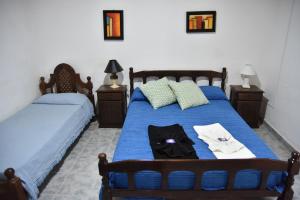 恩鲍斯El Indalo的一间卧室配有两张带蓝色床单和毛巾的床。