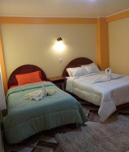 胡利亚卡Hostal Real Divina的一间卧室配有两张带毛巾的床