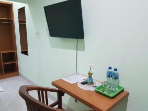 纳闽巴霍科莫多精品酒店 的一张桌子,上面放有笔记本电脑和瓶装水