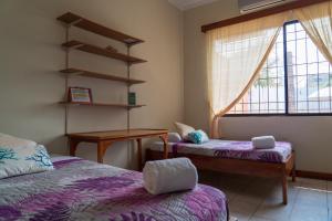 巴克里索莫雷诺港Mare Mio的客房设有两张床、一张桌子和一扇窗户。