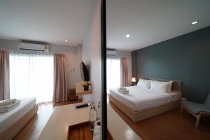 素可泰素可泰花园酒店的卧室配有白色的床和蓝色的墙壁