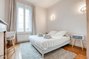 里摩日Maison bourgeoise Haussmannienne - Gîtes de France的白色卧室配有床和书桌