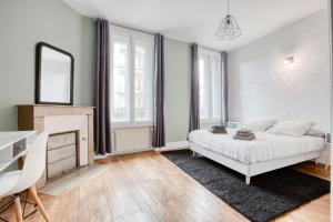 里摩日Maison bourgeoise Haussmannienne - Gîtes de France的一间卧室配有一张床、一张书桌和一面镜子