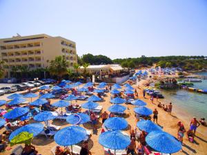 迪迪姆屯塔海滩酒店 - 全包的一群在海滩上戴着蓝伞的人