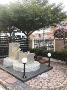 闵埔丽斯玛特公寓的花园,花园的喷泉位于树木繁茂的庭院中