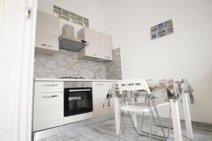 卡塔尼亚Central Luxury Apartment的白色的厨房配有桌子和白色家电