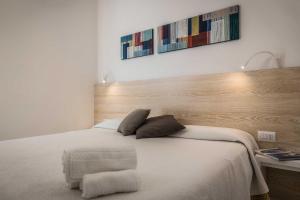 奥特朗托阿尔巴尼亚的卧室配有白色的床和木制床头板
