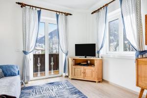 莫埃纳Ciasa Christina的一间卧室设有一张床、一台电视和窗户。