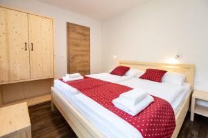 博希尼Bohinj Apartments Goldhorn Kingdom的一间卧室配有一张带红色和白色床单的大床