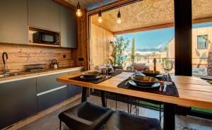 诺瓦利娅Noa Glamping Resort的厨房配有木桌和大窗户。