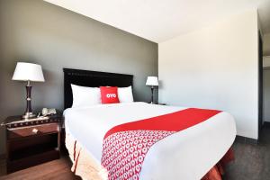 什里夫波特OYO Hotel Shreveport Airport North的一间卧室配有一张大床,铺有红白毯子